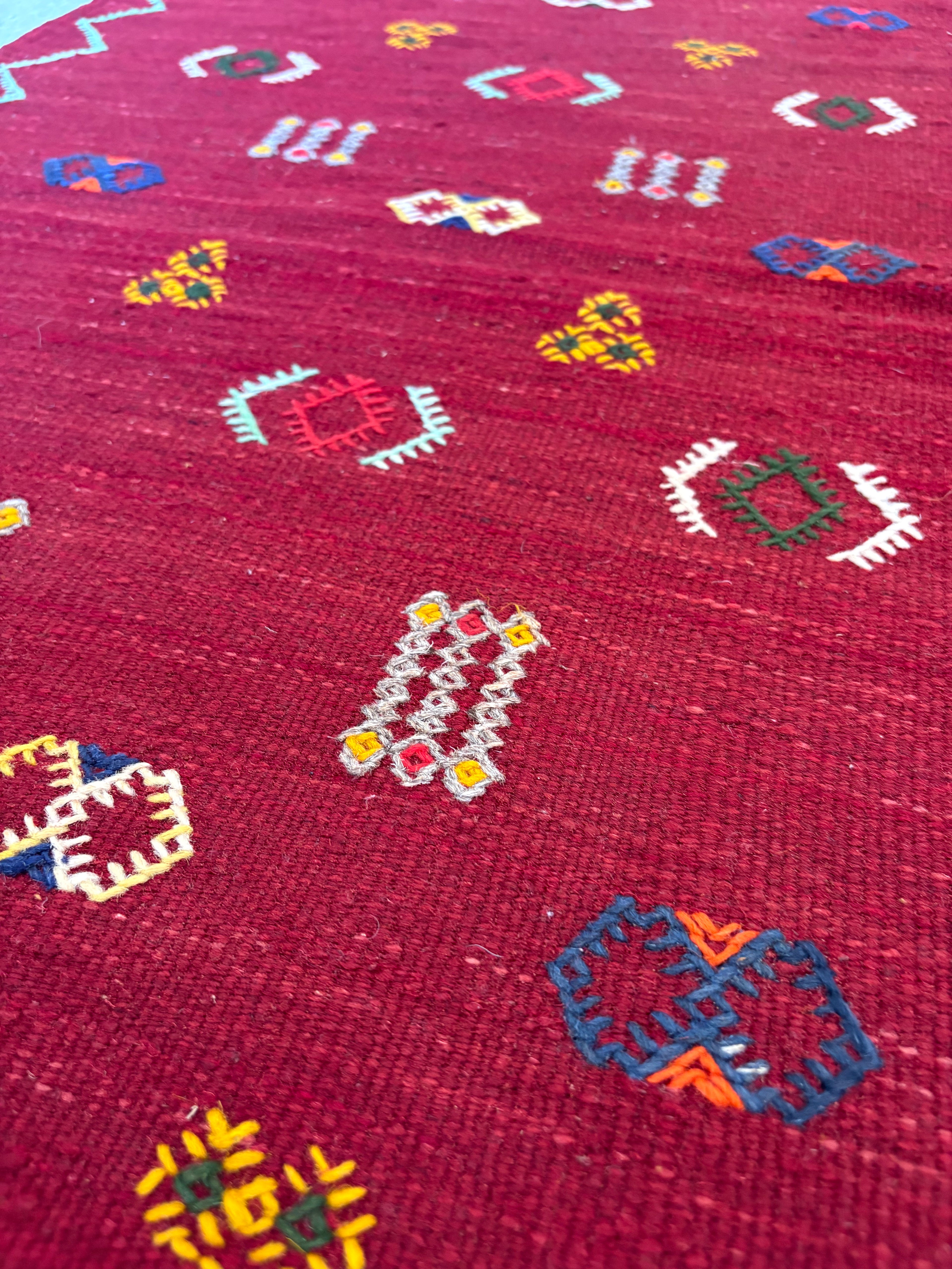 Close-up of handwoven Amazigh motifs on a Moroccan small wool kilim rug