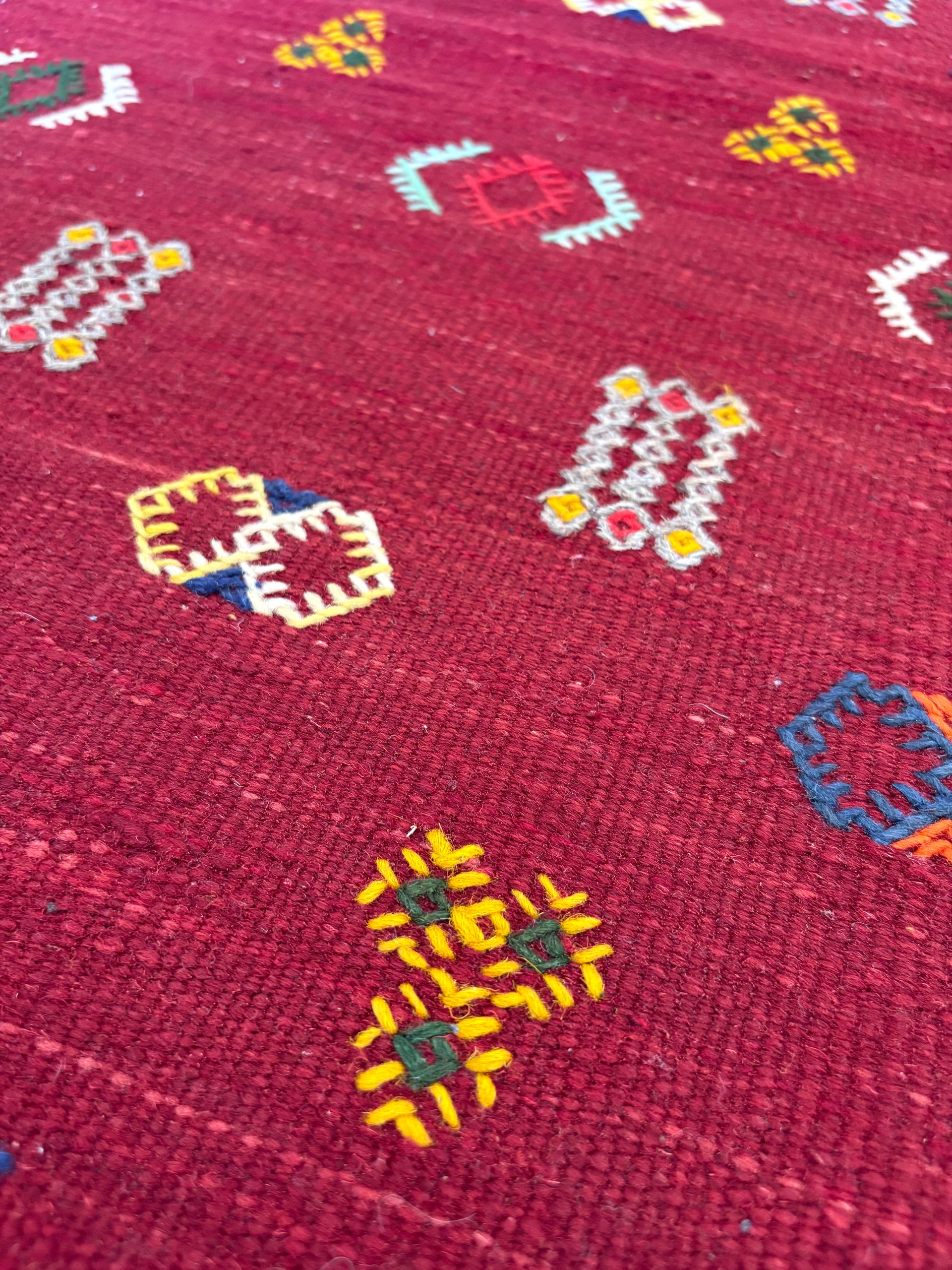 Close-up of handwoven Amazigh motifs on a Moroccan wool kilim rug