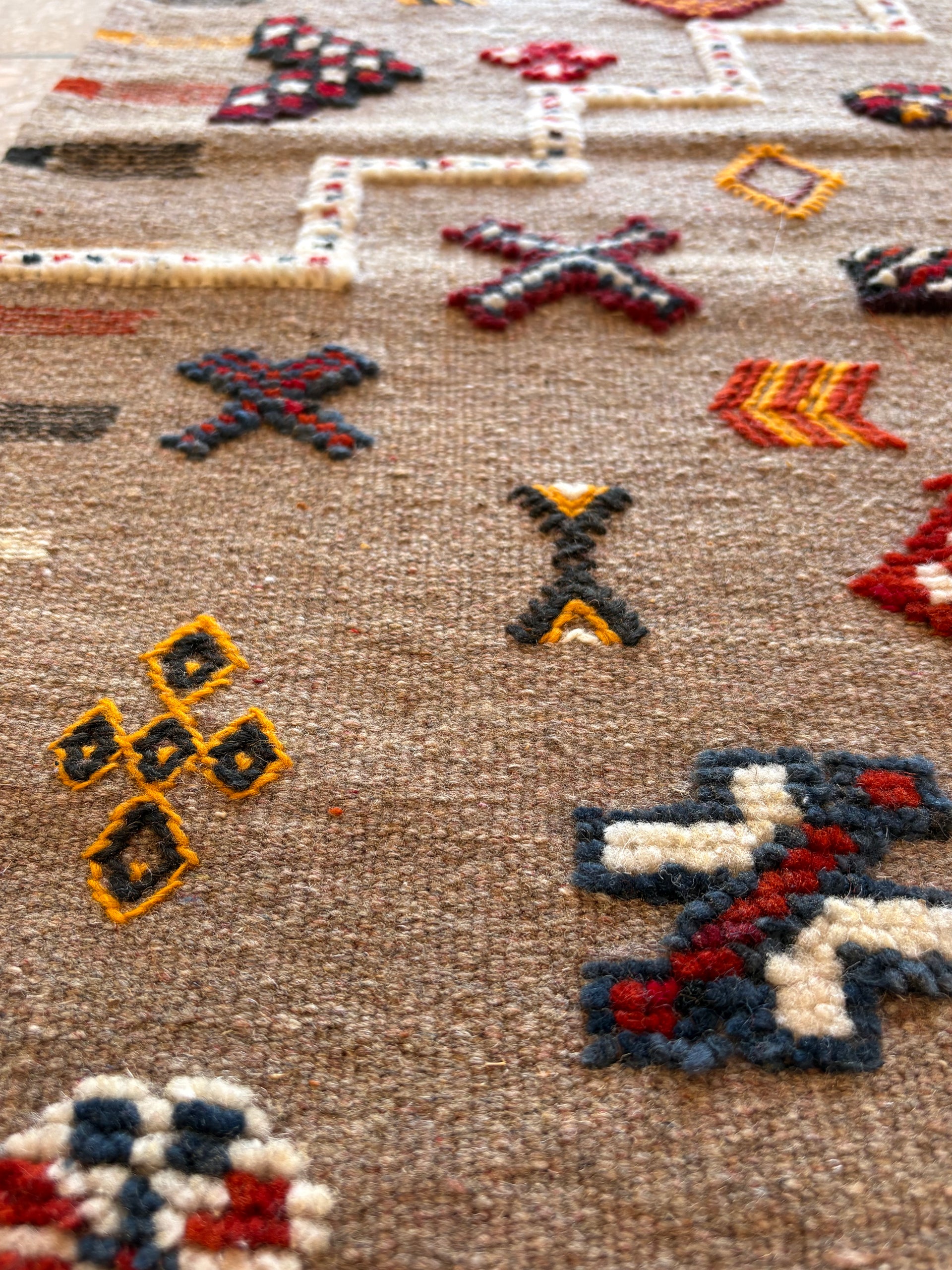 Close-up of handwoven Moroccan kilim rug showing intricate Amazigh symbols