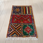 Hand-knotted Moroccan Berber patchwork rug in 100% Atlas Mountain wool featuring four Amazigh symbolic panels, 25 × 42 in (64 × 106 cm).
