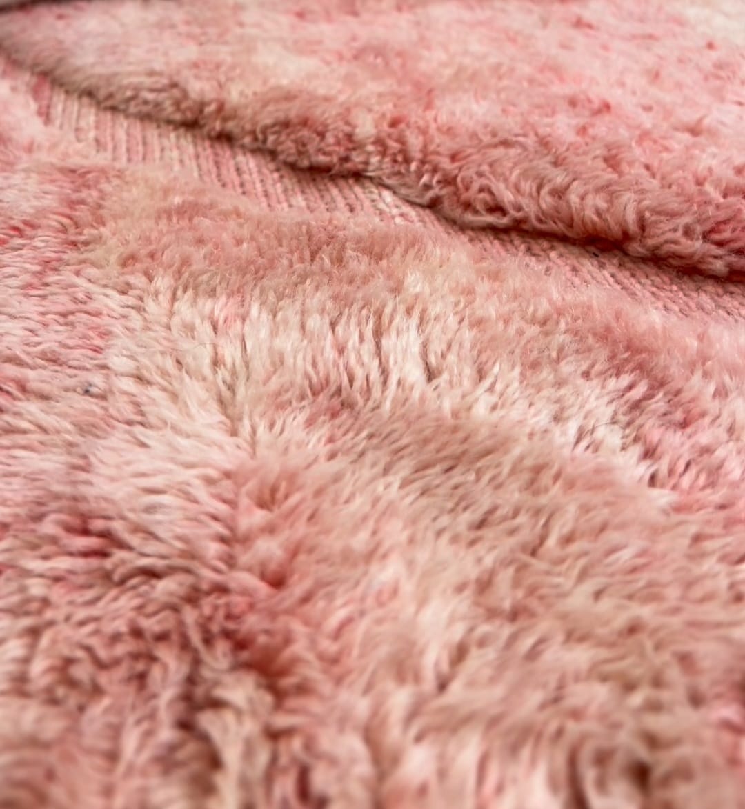 A close-up of a Pink Beni Ourain style Moroccan wool rug 71 x 98 in with long shaggy pile and flat woven diagonals
