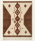 Atlas Passage Beni Ouarain custom Moroccan rug with cocoa geometric forms and protective diamond motifs on ivory wool