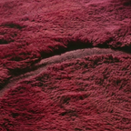Texture detail — Close-up of a burgundy Moroccan rug showing hand-knotted pile beside flat woven bands