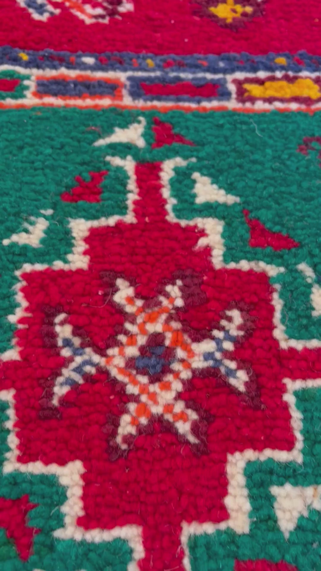 Close-up of hand-knotted Moroccan Berber rug showing intricate Amazigh symbols and wool texture