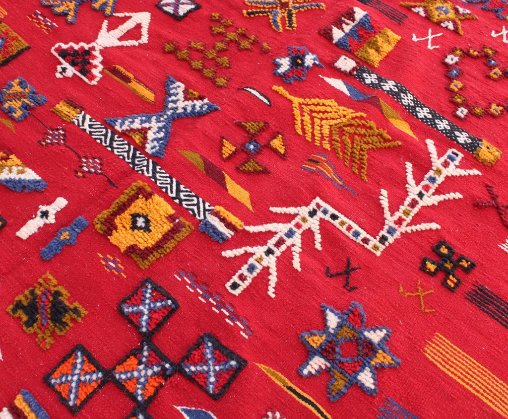 Close-up of Scarlet Notes Taznakht rug showing raised hand-knotted motifs over a flatweave wool ground