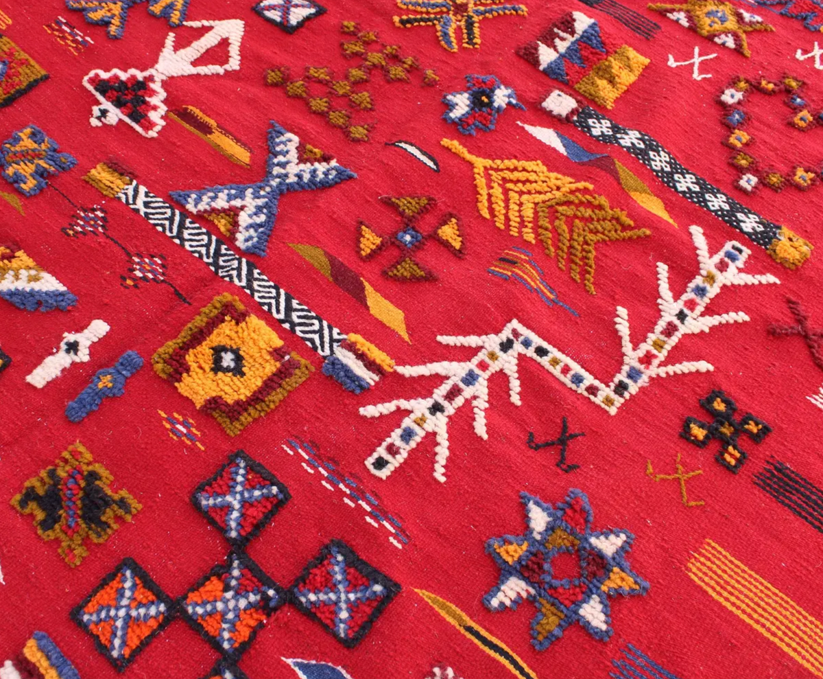 Close-up of Scarlet Notes Taznakht rug showing raised hand-knotted motifs over a flatweave wool ground